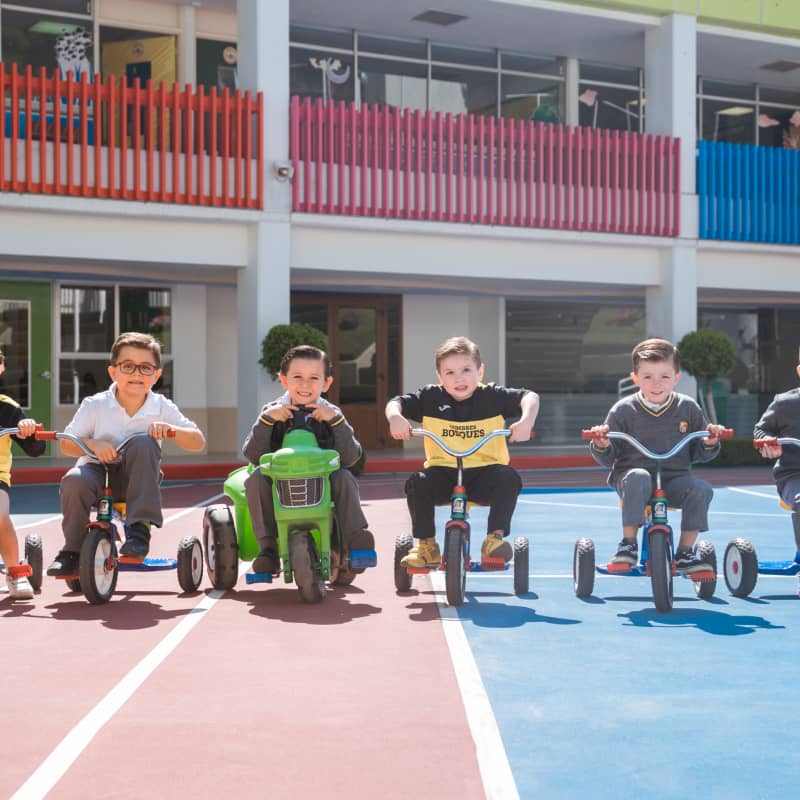 Alumnos de  preescolar en Cumbres Bosques en triciclo 
